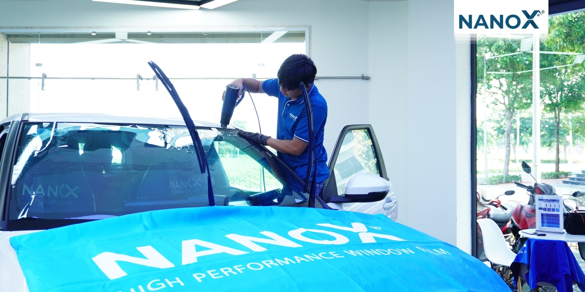 Tiến hành sấy phim cách nhiệt từ phần trung tâm tấm kính
